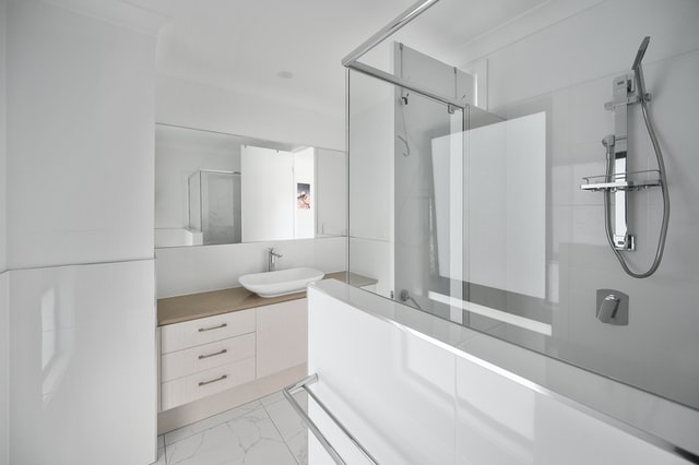 Glass and mirrors used to brighten up a window-free bathroom