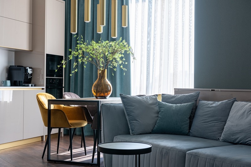 A blue-gray sitting area with brown details and white furnishings